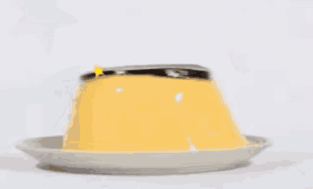 a yellow pudding is sitting on a white plate