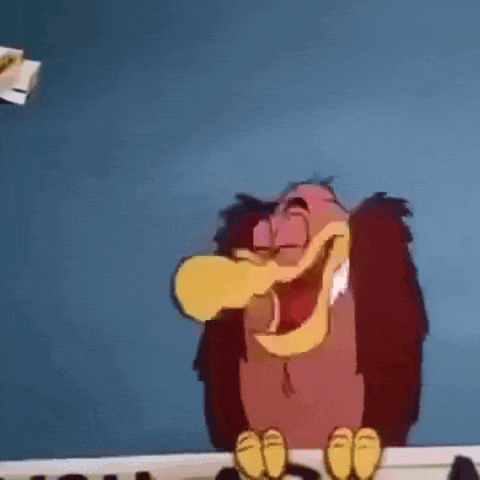 a cartoon vulture with a yellow beak is laughing while sitting on a table .