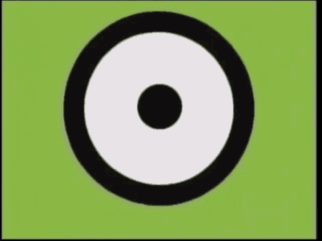 a black circle with a white circle in the middle on a green background .