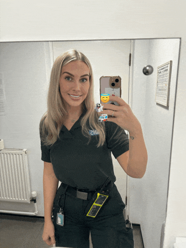 a woman taking a selfie in front of a mirror with a phone case that says ' emoji ' on it