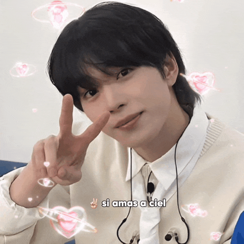a young man giving a peace sign with the words si amas a ciel behind him