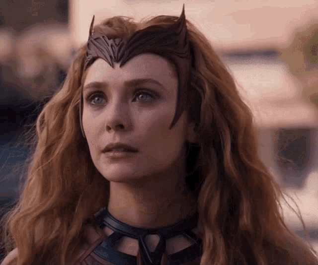a woman with long red hair is wearing a crown