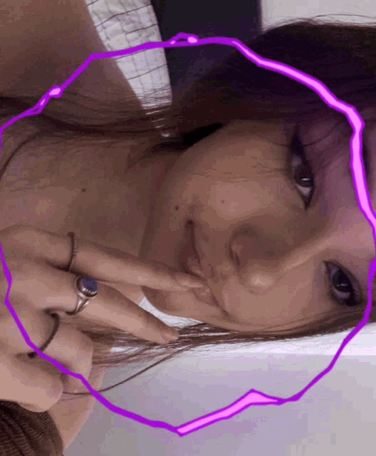 a woman is taking a selfie with a purple circle around her face