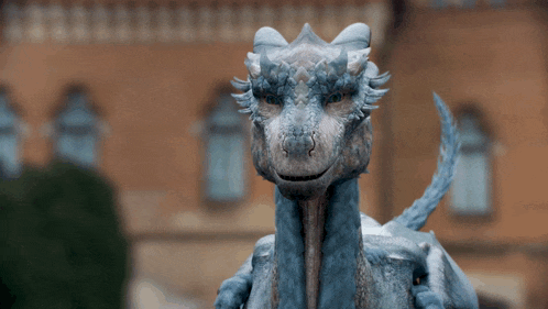 a close up of a dragon 's face with a building in the background