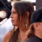 a woman with long hair is sitting next to a man in a baseball cap .