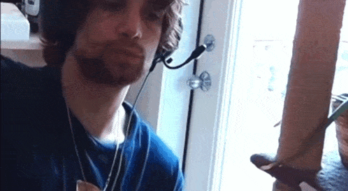 a man wearing headphones and a microphone looks down