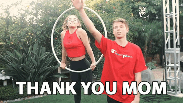 a man in a red shirt is holding a hula hoop next to a woman in a red shirt .