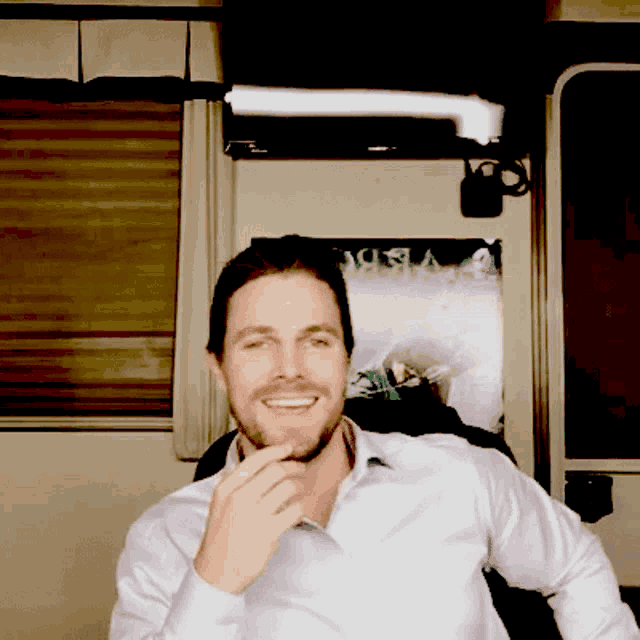 a man with a beard is smiling in front of a screen that says ' a vision '