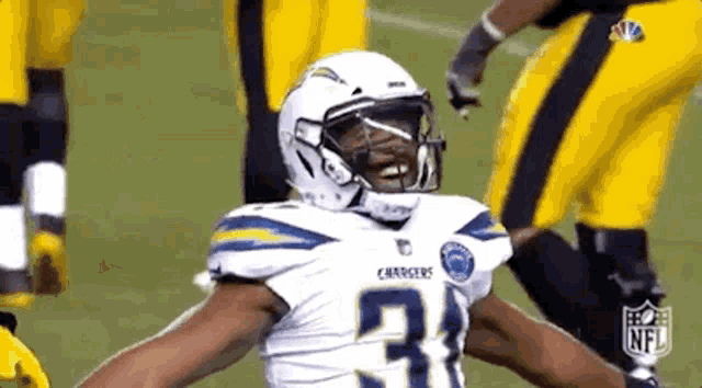 a football player with his arms outstretched is wearing a white helmet and a number 31 jersey .