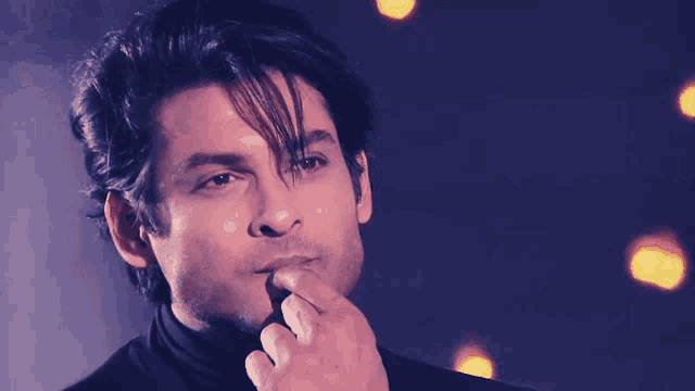 a close up of a man 's face with his finger on his chin