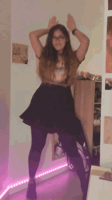 a girl wearing glasses and a black skirt is dancing