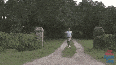 a man is running down a dirt road in a park .
