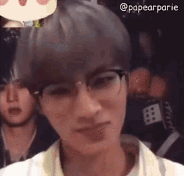 a young man wearing glasses and a white shirt is looking at the camera .