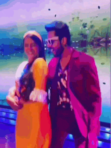 a man in a pink suit and a woman in a yellow dress are standing next to each other .