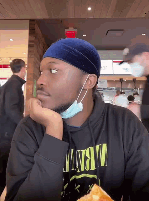 a man wearing a blue headband and a nirvana hoodie