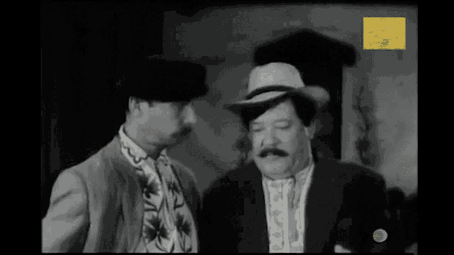 two men are standing next to each other in a black and white photo with a green circle on the bottom