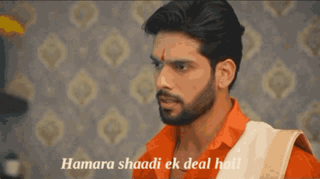 a man with a beard is wearing an orange shirt and a white towel ..