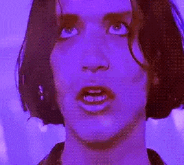 a close up of a woman 's face with a purple background