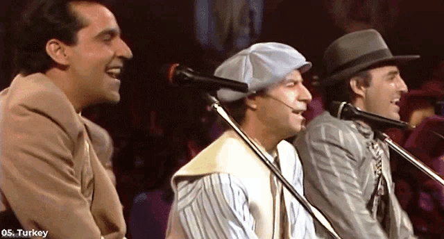 three men singing into microphones with os turkey written on the bottom right