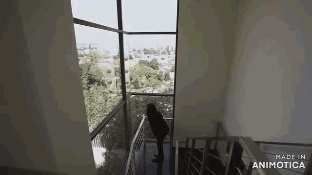 a woman is standing on the stairs of a building with a view of the city .