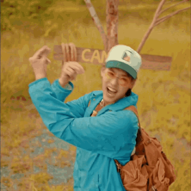 a man in a blue jacket is holding a sign that says spring