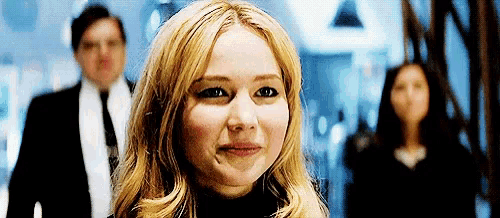 a close up of a woman 's face with a man and woman in the background