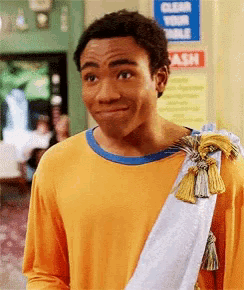 a man wearing a yellow shirt with a white sash around his neck