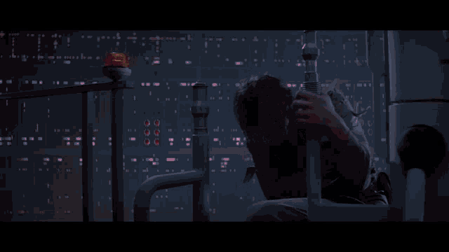 a man is holding a red light saber in front of him