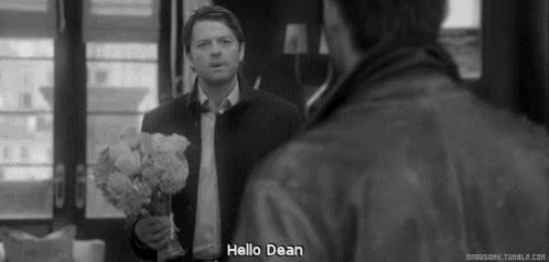 a black and white photo of a man holding a bouquet of flowers .