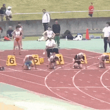a group of athletes are getting ready to run on a track with numbers 6 5 4 and 1