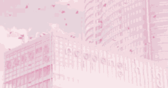 a blurry picture of a city with pink buildings and flowers falling from the sky