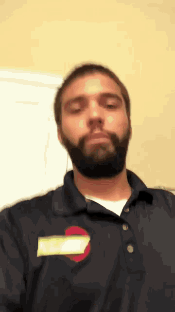 a man with a beard is wearing a shirt with a name tag that says ' chris ' on it
