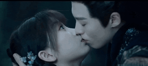 a man and a woman are kissing in a dark room in a movie .