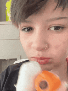 a girl with a nose ring is holding a toy