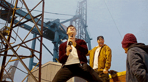 a man in a red jacket is holding a gun in his hand