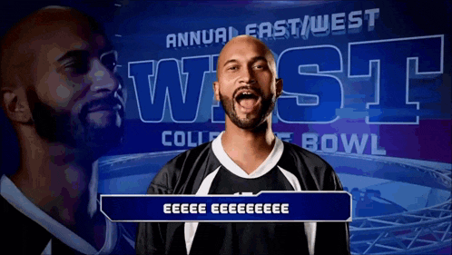 a man stands in front of an annual east west college bowl banner