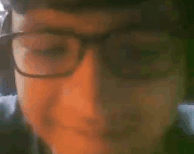 a close up of a person wearing glasses on a video call .