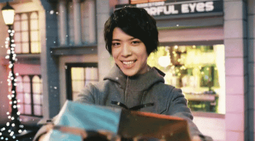a woman is holding a gift in front of a building that says " wonderful eyes "