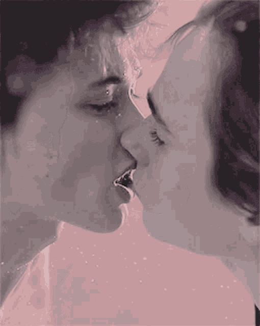 a man and a woman are kissing with their mouths open