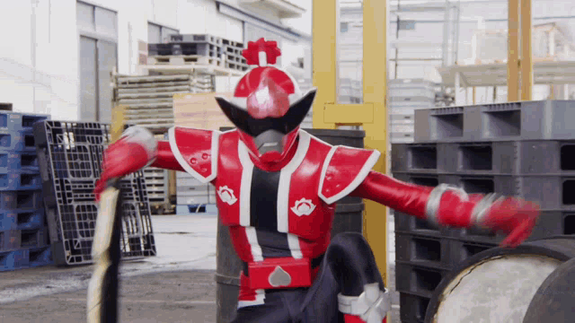 a man in a red and black costume is holding a stick