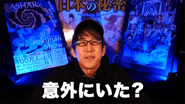a man wearing glasses and a hat stands in front of a sign that says aokman show