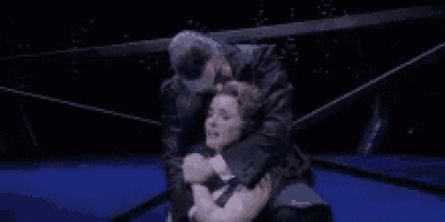 a man is hugging a woman on a stage .