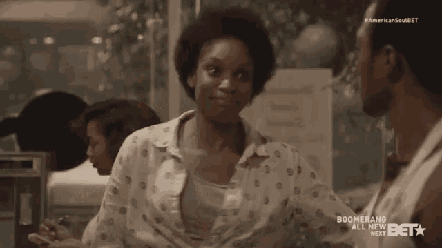 a woman in a polka dot shirt talks to a man in a boomerang ad for american soul bet