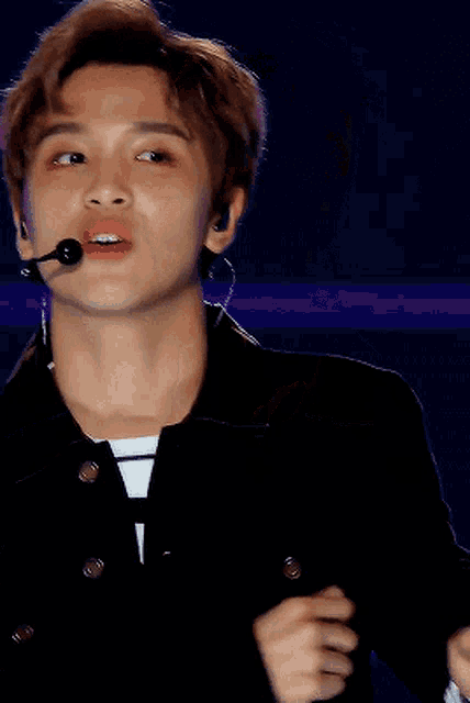 a young man with a microphone in his ear looks at something