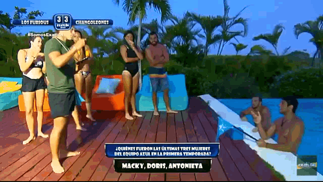 a group of people standing around a pool with a sign that says macky doris antonieta on it