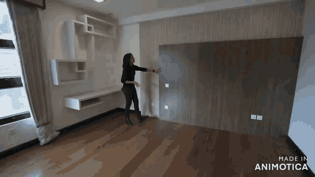 a woman stands in an empty room with the words made in animatica on the bottom right