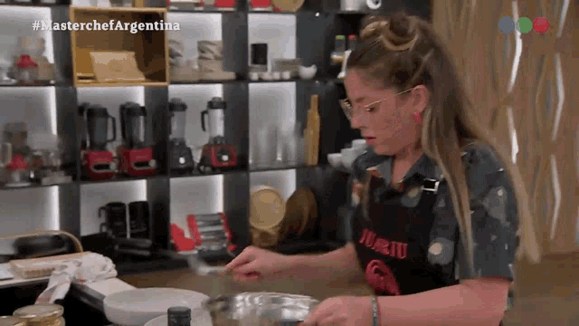 a woman wearing an apron that says jurito on it is cooking in a kitchen