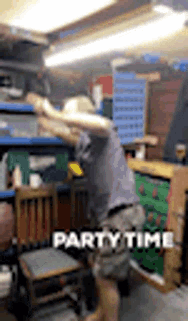 a man in a cowboy hat is standing in a room with a sign that says party time