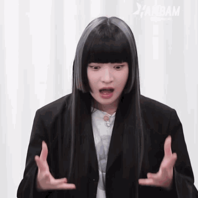 a woman with long black hair and bangs is making a funny face