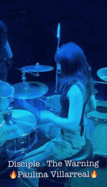 a woman is playing drums in a band called disciple the warning